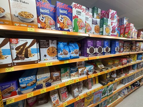 Calvia, Spain - June 07, 2026: Variety of breakfast cereal boxes displayed on supermarket shelves, including Kellogg's Frosties, Special K, and Corny brands