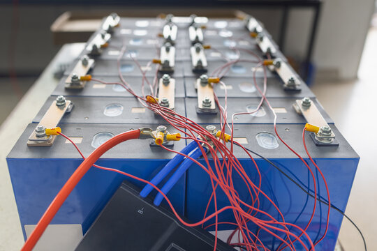Technician connect BMS (Battery Management System) wires to Lifepo4 battery pack for solar system.  Lifepo4 Battery Management System Concept.