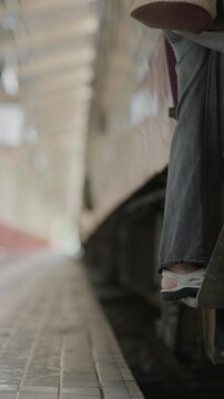 Traveler stepping onto a train with a bag, ideal for rail travel, public transport, boarding, journey, departure, tourism and travel movement concepts.