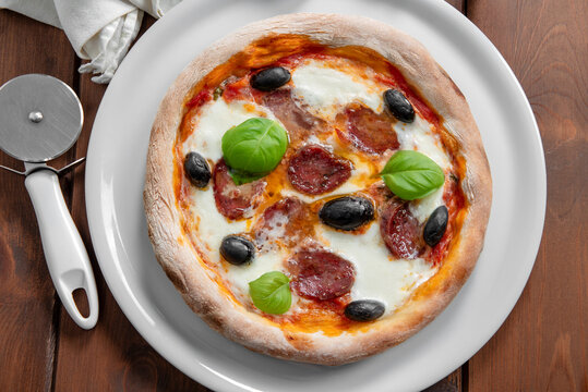 Pizza italiana con pecorino, salame e olive nere 