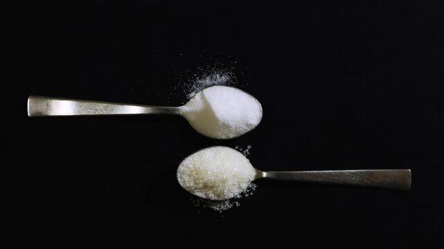 granulated sugar and table salt on metal spoons highlighting sweet and savory ingredient contrast