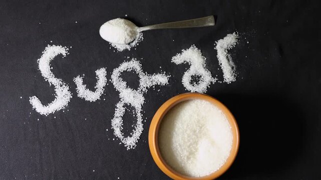 granulated sugar background with artistic sugar lettering and copy space for nutrition theme