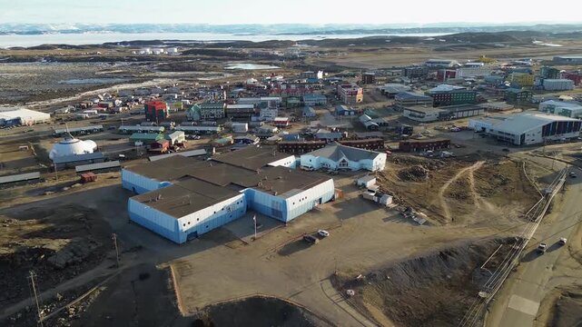 High-angle drone shot capturing the unique polar architectural design of Inuksuk High School and the Aquatic Centre in Iqaluit, Nunavut.