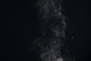 Fototapeta premium White steam smoke rising and swirling on a black background