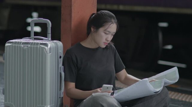 Traveler sitting at a train station and reading a map, ideal for travel planning, navigation, tourism, railway journey, backpacking and trip concepts