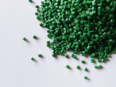 Green polymer granules, green masterbatch granules, cold cutting material type, isolated on white background for product catalog design of plastic manufacturing industry company profile	