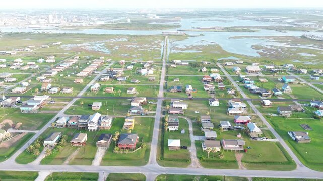 Wetland harbor contrast shows homes north of Seashell Dr facing marsh corridor leading toward Freeport Harbor Channel tank clusters. Broad lawns, muted roof colors, elevated grid in Freeport, TX