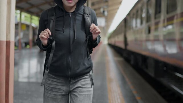 Backpack traveler walking on a train platform, ideal for rail travel, tourism, public transport, commuting, solo journey, backpacking and adventure concepts