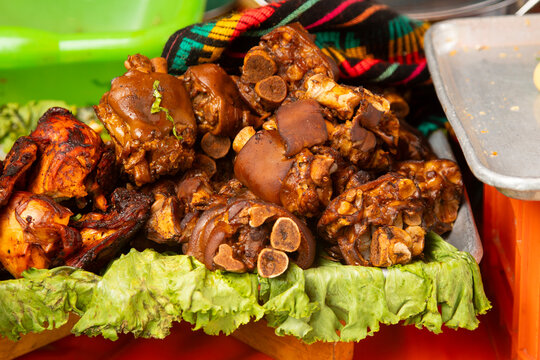 Close-up of tender, roasted cochito horneado served on a rustic clay platter with fresh parsley garnish in Chiapas del Corzo, Mexico.
