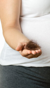 Pregnant woman hand palm holding a hairs and a comb