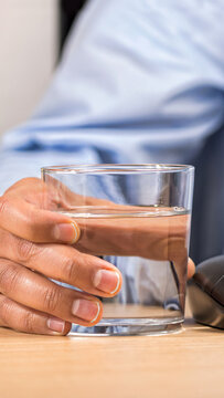 hand of a businessman in the office drinking a glass of mineral water