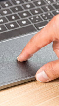 Hand of a businessman working on the laptop and using the touchpad