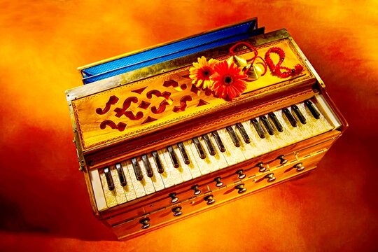 Harmonium Musical Instrument: An ornate Indian harmonium, a portable reed organ with keyboards and bellows, adorned with vibrant flowers and ribbons.