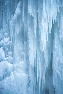 View of massive frozen icicles and snow-covered rock formations along the Icefields Parkway in Jasper, Alberta, Canada.