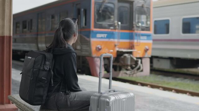 Digital nomad traveler waiting at a train station with backpack and suitcase, ideal for travel lifestyle, remote work, solo journey, tourism and modern mobility concepts.