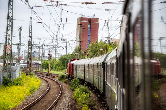 Historischer Zug bei der Einfahrt in einen Bahnhof in einer Kurve mit Diesellok