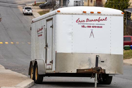 La Tuque, Canada, 01 May 2026 : A white utility trailer with 'Eric Bonenfant Entrepreneur General' branding is parked on a residential street.