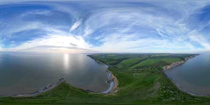360&deg; Panorama Aerial Drone Shot Over Coastal Cliffs, Green Hills, and Calm Sea at Dunraven Bay, South Wales, United Kingdom