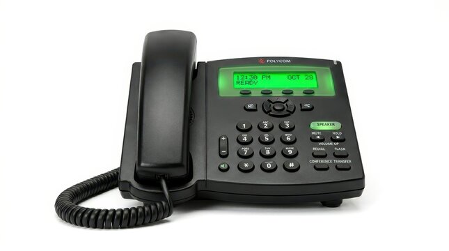 Black office desk phone with a corded handset and green digital display screen isolated on white background
