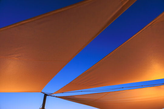 the modern Shade Sail against dark blue sky at blue hour, desert vacation, moroccan style