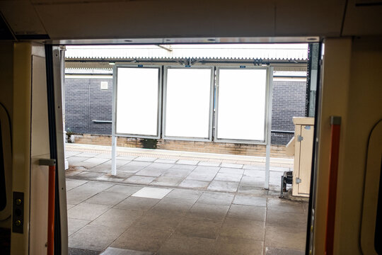 LONDON - blank advertising panels on train station platform viewed from inside train