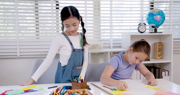 caucasian girl elementary student focusing on drawing activity using pencil during classroom art lesson while sitting at desk creativity childhood education learning study concentration diligence