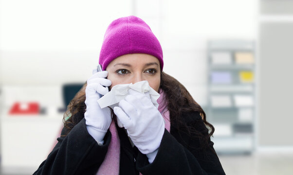 Sick businesswoman with tissue, hat and gloves, flu or allergy with cold, illness during a phone call, portrait. Secretary sneezing or receptionist blowing nose with tissue paper