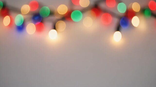 Colorful Christmas Lights Creating Soft Bokeh Particles on White Background, Seamless Loop of Festive Holiday Motion Graphics Full HD