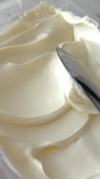 Close up of creamy whipped ganache texture with silicone spatula creating waves on dessert surface