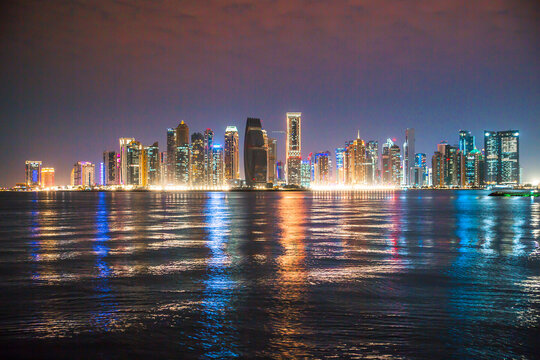 Beautiful night view of Doha city, skyscrapers of financial area and reflection in bay water. Qatar 