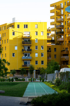 yellow apartment buildings face a courtyard lawn in Nordbahnviertel Vienna Austria where balconies windows and pathway frame colorful housing