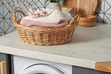 Clean Laundry Basket with Soft Towels and Pink Flowers on Countertop Near Washing Machine