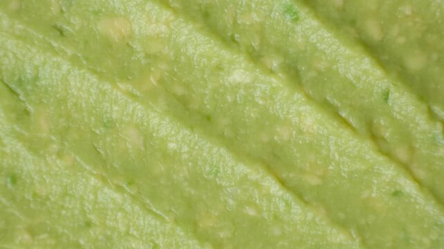 Full frame texture of green homemade guacamole sauce top view.