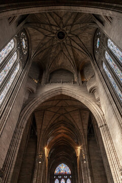 View of the magnificent Gothic revival interior of Liverpool Cathedral featuring high vaulted stone ceilings and intricate stained glass windows in Liverpool, England, United Kingdom.