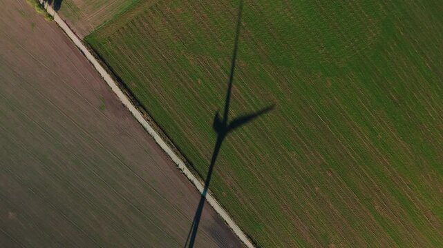 Top down view of wind turbine shadow casting over agricultural fields