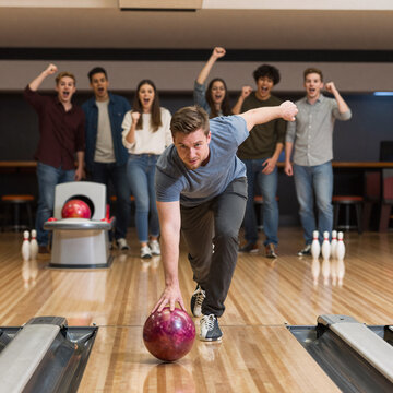 Whimsical Bowling Jeans. Group Of Friends Cheering For A Man Bowling