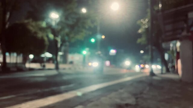 Blurred vehicle movement at a traffic light intersection at night, urban city scene with glowing lights, motion blur effect and transportation concept.
