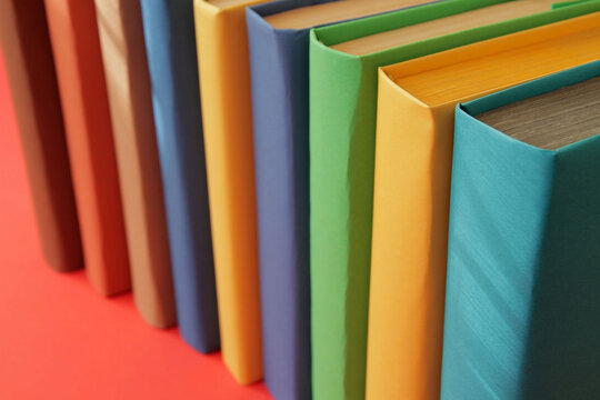 Concept: Books arranged in a row with colorful covers on colorful paper backgrounds. Color symbolism characterizes the diversity of information topics. Paper with popular complementary colors.