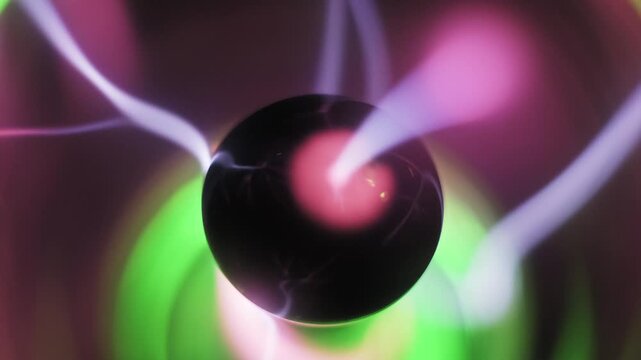 Macro view of a plasma ball where bolts swirl around the central electrode. Pink and green ionized gas tendrils move inside the transparent sphere with blurry light rings.
