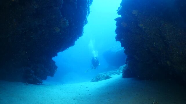 cave diving underwater scuba divers exploring caves and having fun ocean scenery sun beams and rays background