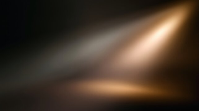 Dramatic spotlight illuminating a dark stage or studio with a warm golden glow and soft focus