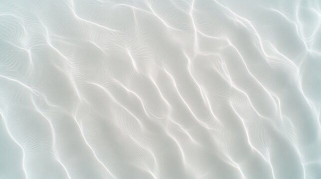 Aerial view of shallow tropical water with sunlight reflecting on the sandy seabed creating wavy patterns