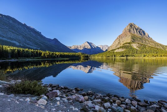 240831_066 Rippled reflection of the mountains on the calm waters of Lake Josephine in Glacier National Park, Montana, USA