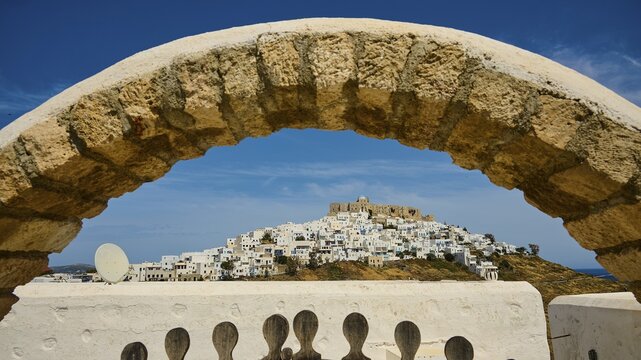 Stone arch frames the view of a hilltop village with a fortress, Querini Castle, Chora, Astypalea, Dodecanese, Greek Islands, Greece
