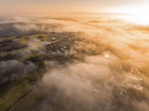 Luftaufnahme eines Dorfes im Nebel mit warmem Morgenlicht, die Landschaft wirkt weich, Gechingen, Heckeng&auml;u, Landkreis Calw, Deutschland