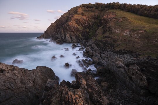 Sunset, Byron Bay, New South Wales, Australia. Waves crashing on rocks at the most easterly point of the mainland during the magical blue hour