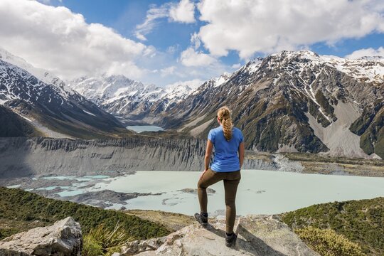 Hiker standing on rocks, view into the Hooker Valley from Sealy Tarns Track, glacial lakes Mueller Lake and Hooker Lake, Mount Cook National Park, Canterbury Region, South Island, New Zealand