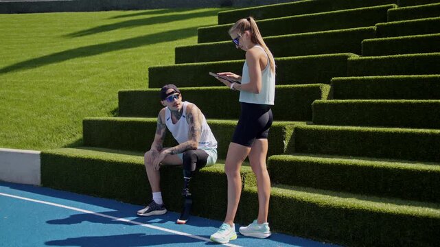 Runner with prosthetic leg rests as instructor fills digital form