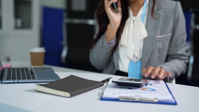 Business woman working on laptop and accounting financial report, accountant using calculator to calculate tax refund at office.
