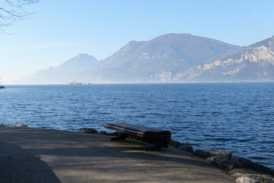 Peaceful lakeside landscape with tree and mountains in Malcesine, Lake Garda, Italy